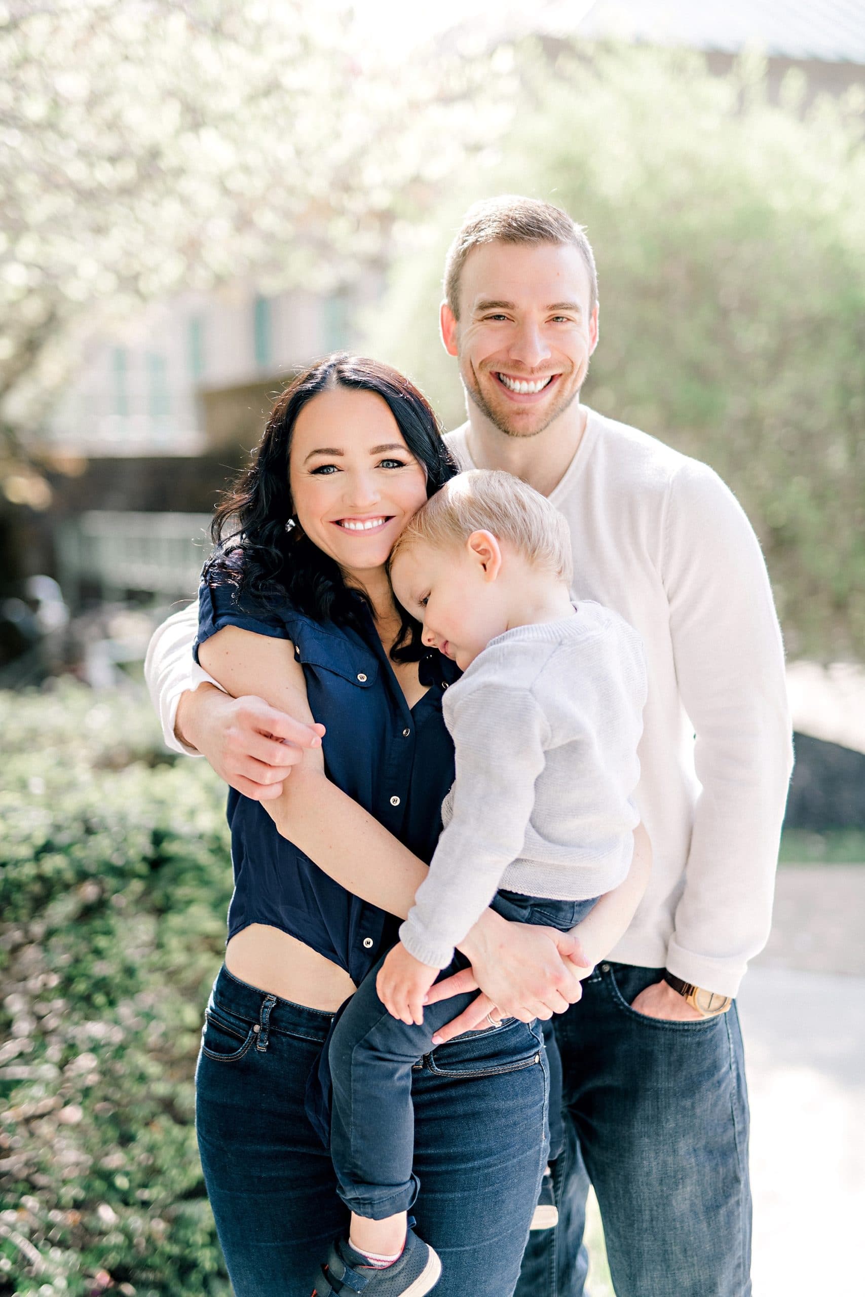 joy filled parents cuddling their little boy during a family portrait session