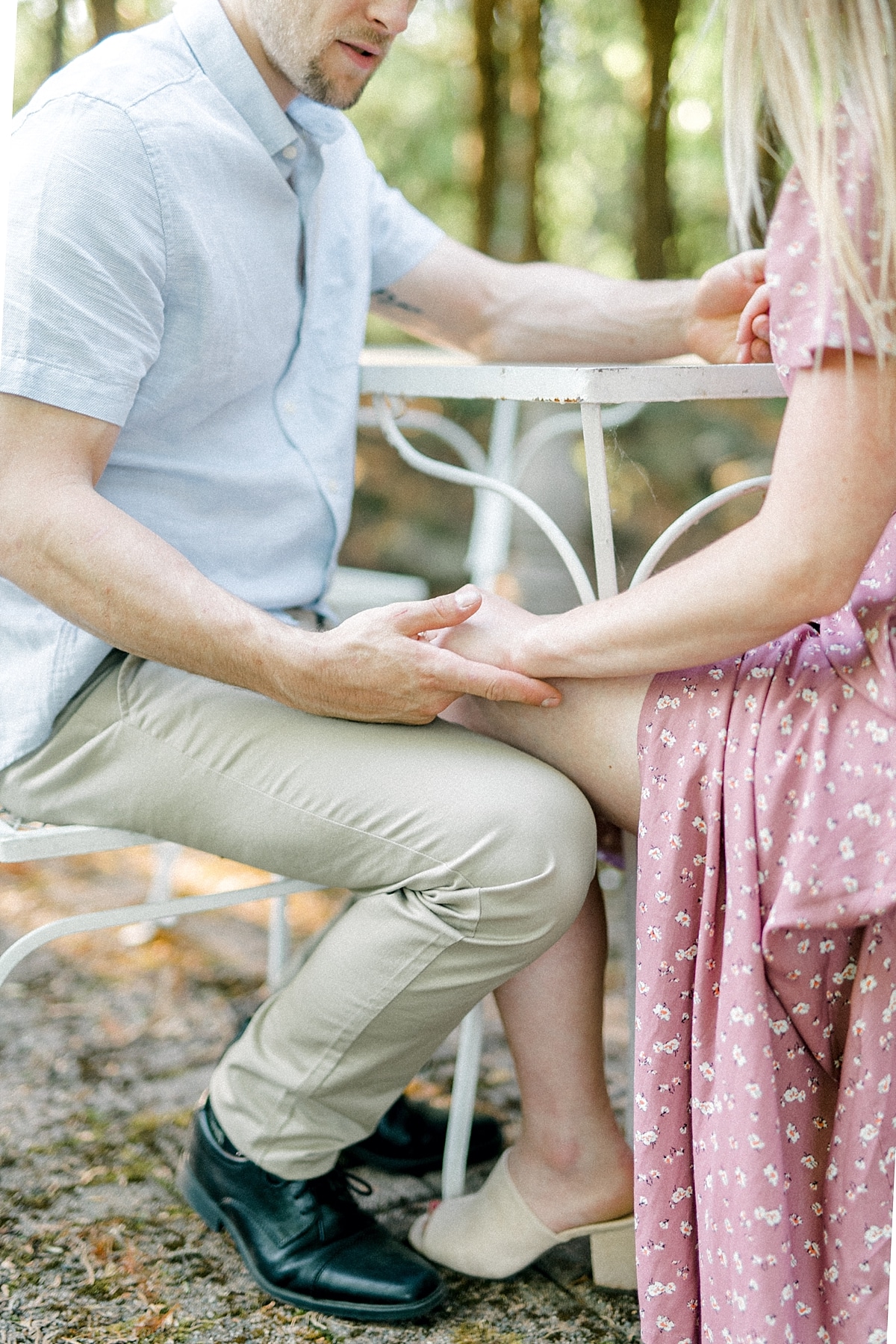 engaged couple sitting knee to knee holding hands