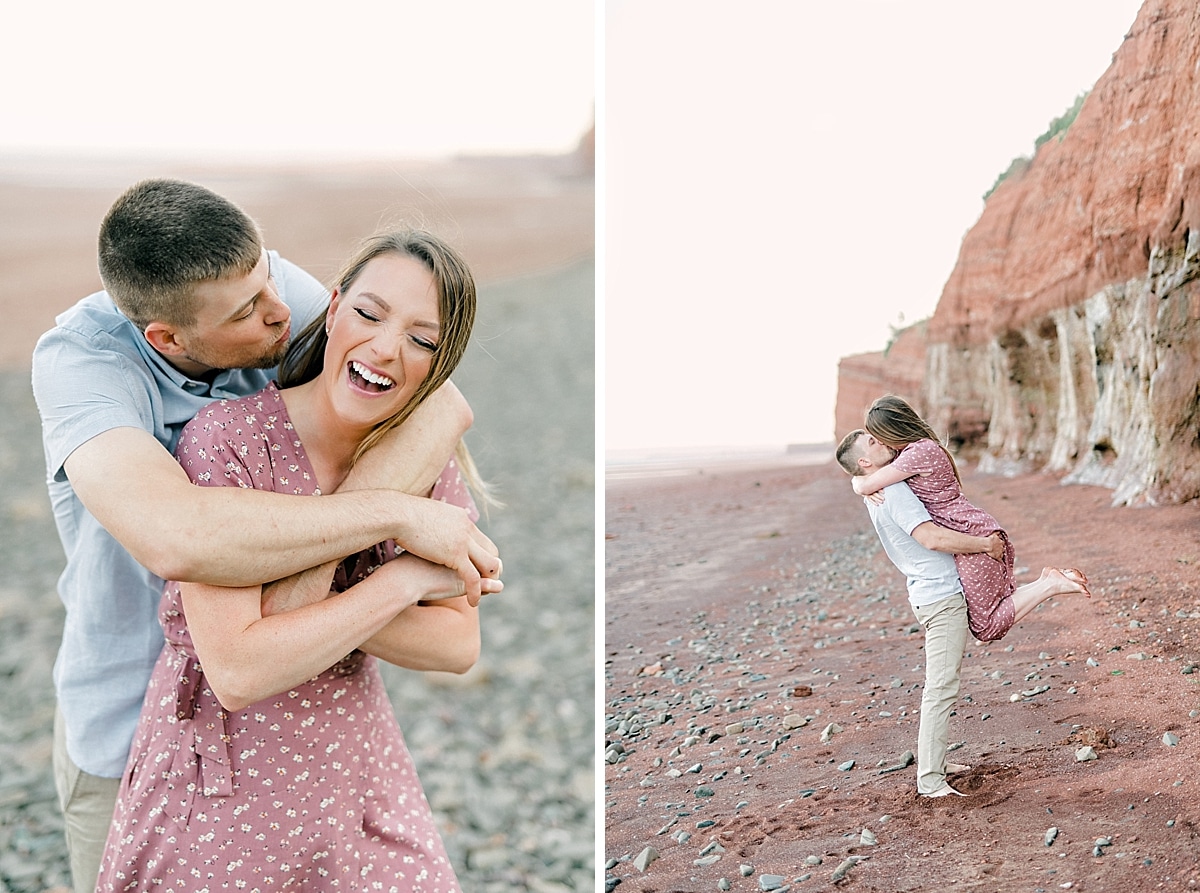 couple laughing and dancing and spinning on the red sand beach at sunset